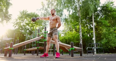 Man practicing workout exercise on outdoor sports ground.Guy training lifting Stock Footage 156928921