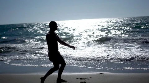 Man practicing yoga and tai chi at sunset at the beach. Slow motion Silhouette Video stock 100174395
