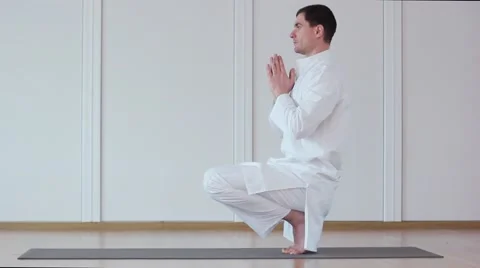 Man Practicing Yoga. He Sits in a White Suit in asanas. Stock-Footage 59730249