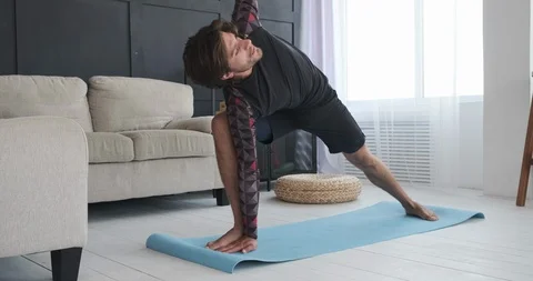 Man practicing yoga at home Stockbeeldmateriaal 117703609