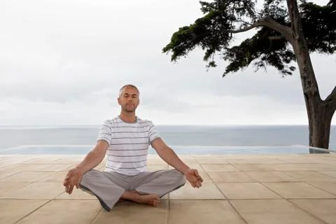Man Practicing Yoga By Infinity Pool Stock Photos