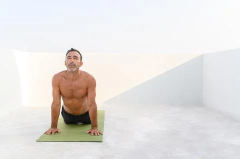 Man practicing yoga on mat - copyspace Stock Photos