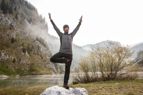 Man practicing yoga, performing a tree pose Stock Photos