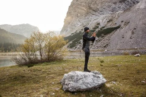 Man practicing yoga, performing a tree pose Stock Photos