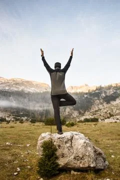 Man practicing yoga, performing a tree pose Stock Photos