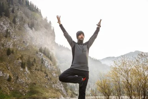 Man practicing yoga, performing a tree pose Stock Photos