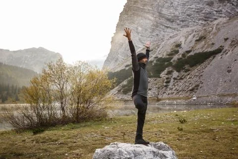 Man practicing yoga, performing a tree pose Stock Photos