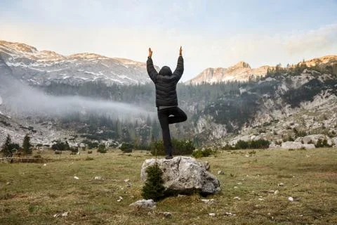 Man practicing yoga, performing a tree pose Stock Photos