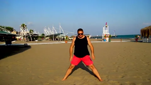 A man is practicing yoga at sandy beach during sunny summer day in Antalya 動画素材 143294098