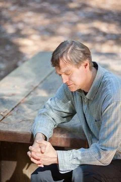 Man praying alone in middle of forest Stock Photos