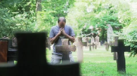 Man praying at cemetery Stock Footage 27762961