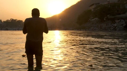 Man praying in Ganges river India, sunset Stock Footage 125747008