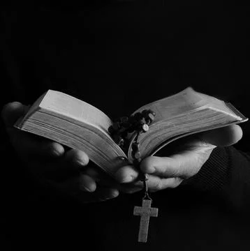 Man praying with hands on bible with people stock photo Stock Photos