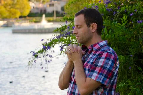 Man praying by a lake. Stock Photos