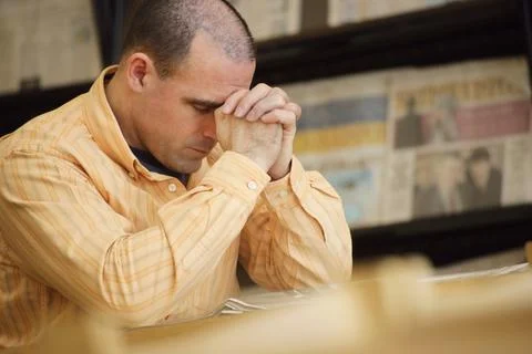 Man Praying In Library Foto stock