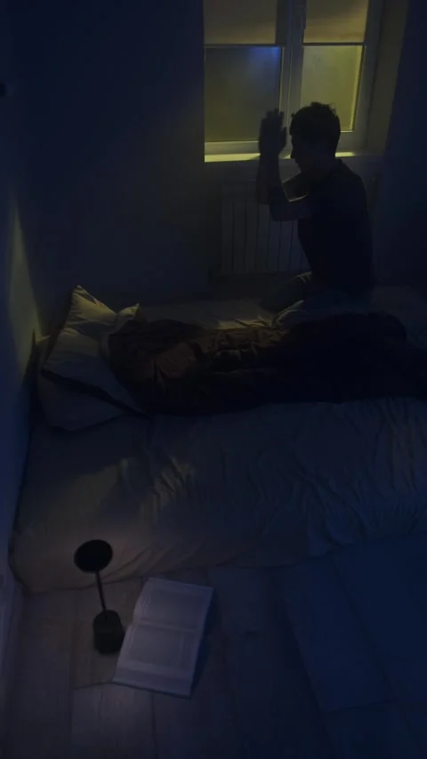 Man praying at night beside open holy book, seeking hope and comfort Stock Footage 320247525
