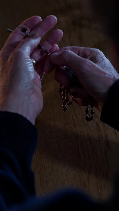 Man praying with rosary beads over the shoulder shot vertical video Video stock 291524980