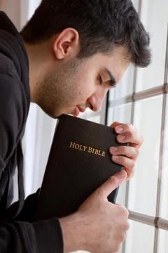 Man praying by window Stock Photos