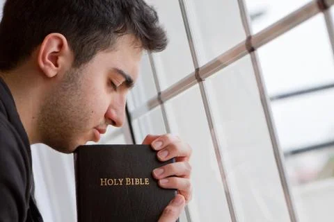 Man praying by window Stock Photos