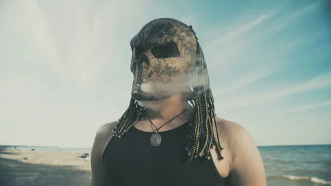 A man in a predator mask poses on the beach. Stock-Footage 91709897