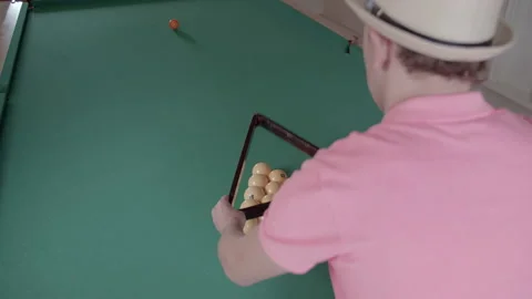 Man prepares billiard balls for the beginning of the game collects in a triangle Stock Footage 154562867