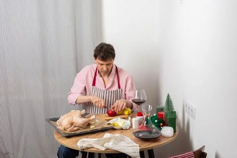 A man prepares a chicken on a baking tray along with potatoes for a pre-Chris Stock Photos