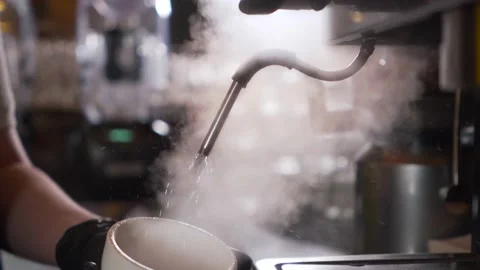 A man prepares coffee close-up. A white Cup for coffee or tea is heated by a hot Stock Footage 145477990