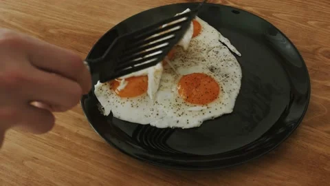 Man prepares eggs in a frying pan. making himself breakfast. Stock Footage 151690557