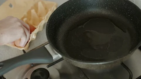 Man prepares eggs in a frying pan. making himself breakfast. Stock Footage 151690758