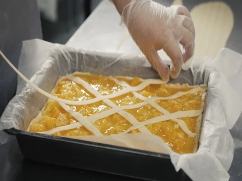 Man prepares a fruits orange lemon pie on a kitchen table, final decoration in Stock Footage