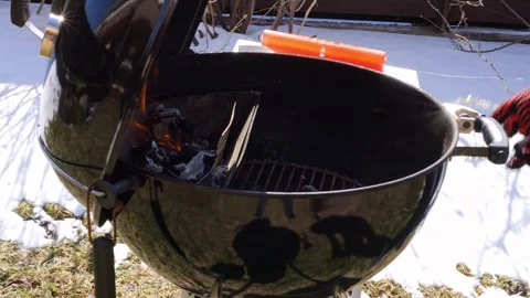 Man prepares grill, getting ready to barbecue meat. Watch as he tends to flames Stock Footage 270844282