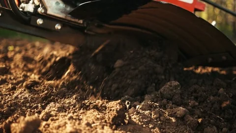 A man prepares the ground with a walk-behind tractor. Stockbeeldmateriaal 162194012