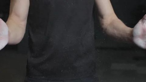 Man prepares for gym workout with chalk on hands showing strength Stock Footage 323446056