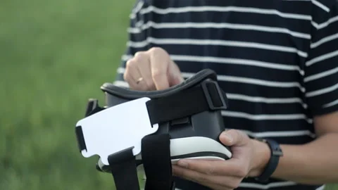 The man prepares the helmet for virtual reality to use Stock Footage 92280609