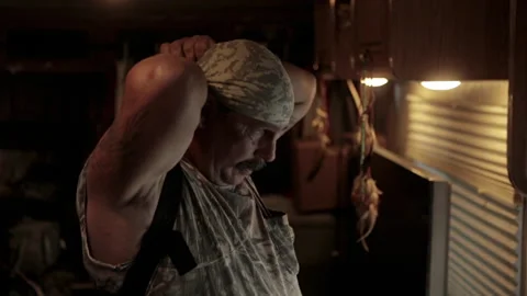 Man prepares himself for work in a kitchen at the break of dawn Stock Footage 327958560