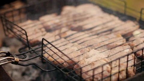 Man prepares large pieces of meat on the grill, turning for roasting Stock-Footage 115471552