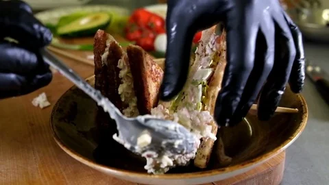 Man prepares lunch, serves grilled bread sandwich snack on top of wooden cutting Stock Footage 85439361