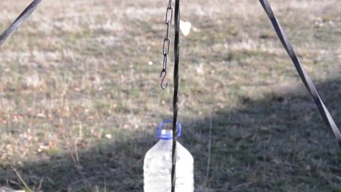 Man prepares to make a stew kettle. He made fire wood, put the kettle on the  Stock Footage 78218711