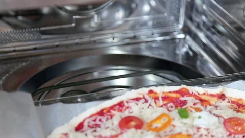 A man prepares pizza and puts it in the oven Stock-Footage 86462384