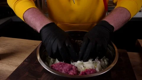 A man prepares a roll of dough stuffed with meat, onions and spices Video stock 136830236