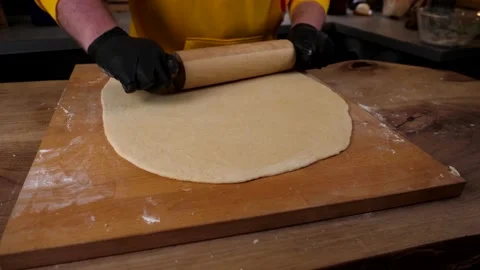 A man prepares a roll of dough stuffed with meat, onions and spices Stock Footage 136830347