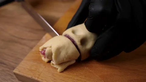 A man prepares a roll of dough stuffed with meat, onions and spices Stock-Footage 136830364
