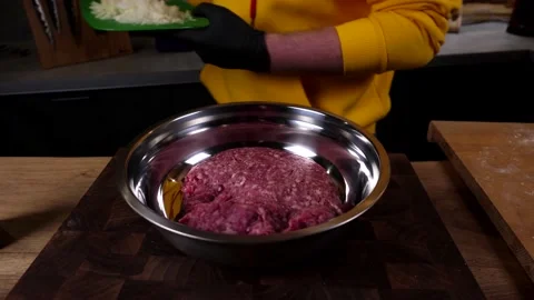 A man prepares a roll of dough stuffed with meat, onions and spices Video stock 136830517