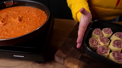 A man prepares a roll of dough stuffed with meat, onions and spices Video stock 136830592