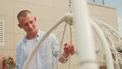 Man prepares romantic setup, Male prepares swing for romantic evening occasion Stock Footage 331067667