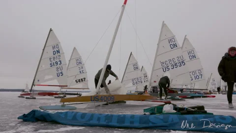 A man prepares the sail of his DN iceboat Stock Footage 158904963