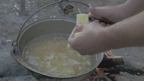 Man prepares soup on a campfire in the forest Video stock 135839230