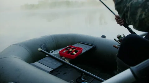 A man prepares spinning while sitting in a boat. Morning fishing Stock Footage 237361697