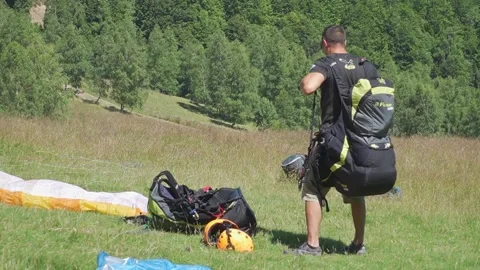Man Prepares for Takeoff, Securing Paragliding Gear Stock-Footage 304567438