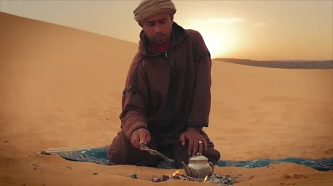 Man prepares tea in the desert Stock Footage 58593797